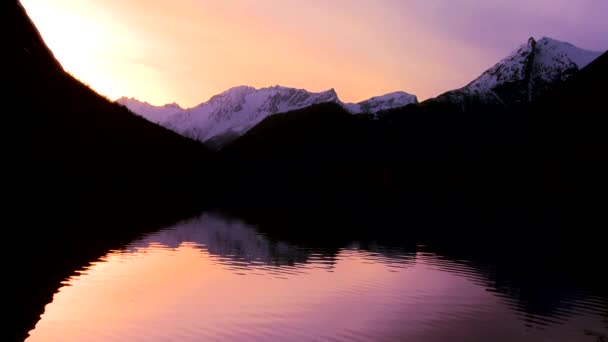 Reflexão em um lago de montanha ao pôr do sol — Vídeo de Stock