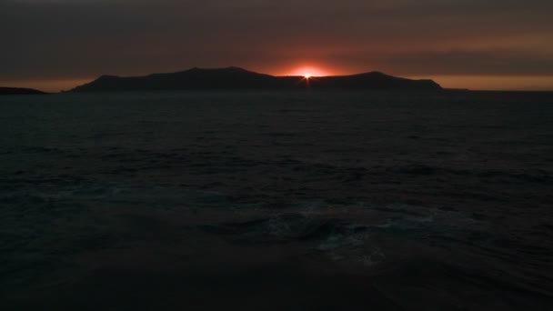 El sol se pone detrás de una isla — Vídeo de stock