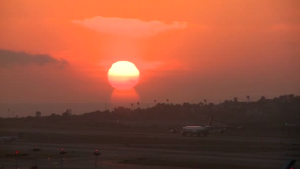 Een vliegtuig opstijgt in de zonsondergang — Stockvideo