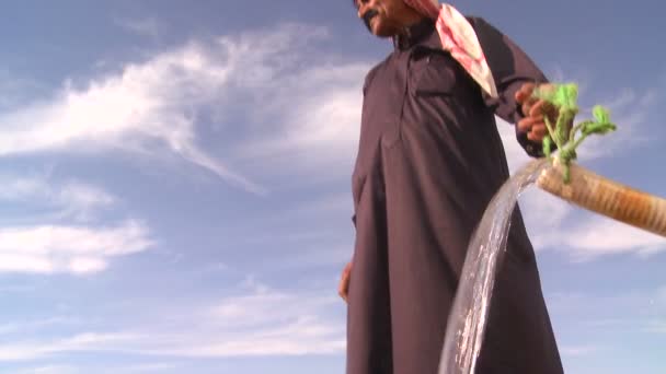 Bedouin biedt kostbare water in woestijn — Stockvideo