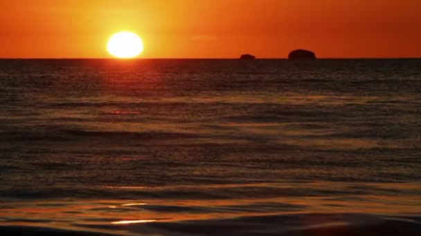 Волны ломаются на пляже на закате — стоковое видео