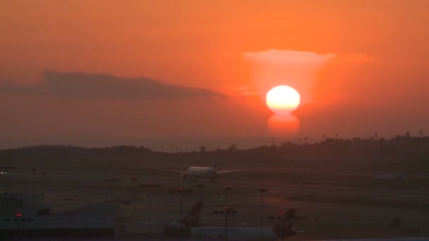 Un avión despega hacia el atardecer — Vídeos de Stock