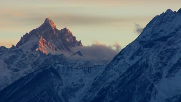 La luz del sol brilla en los picos de una montaña — Vídeos de Stock