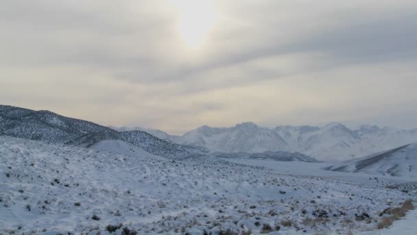 Licht schijnt neer op een besneeuwde landschap — Stockvideo