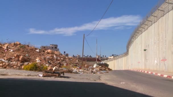 Recolección de basura a lo largo de la base de la barrera de Cisjordania — Vídeo de stock