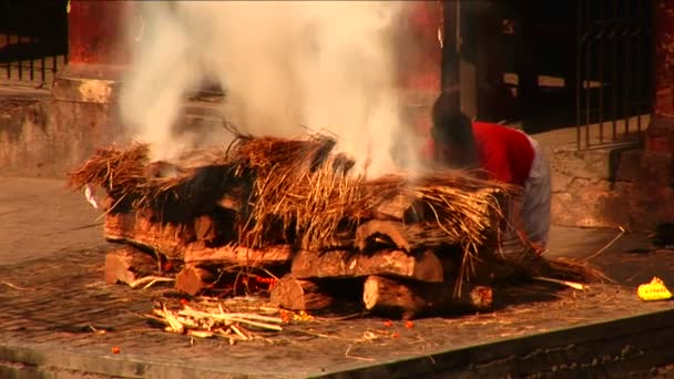 Человек, разжигающий большой церемониальный огонь — стоковое видео