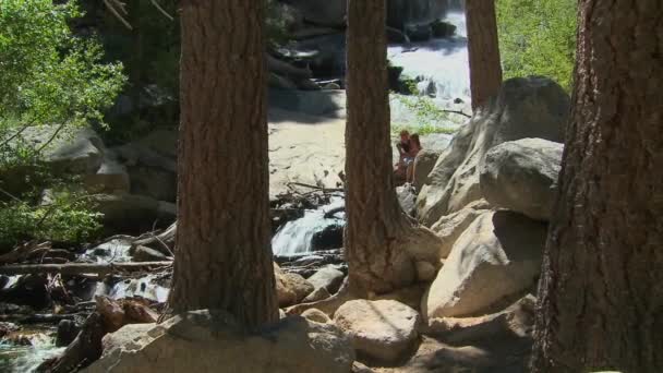 Moeder en dochter genieten van moment naast een waterval — Stockvideo