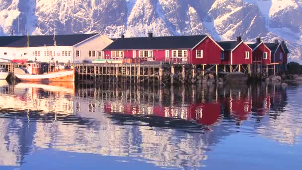 Peaks loom behind fishing village — Stock Video