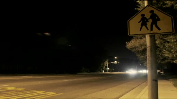 Tráfico que pasa por un paso de peatones por la noche — Vídeo de stock