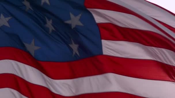 Una bandera americana ondea con el sol detrás — Vídeo de stock
