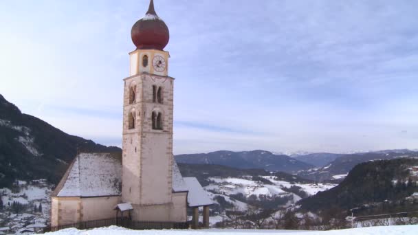Kyrkan i en insnöad tyrolska by — Stockvideo
