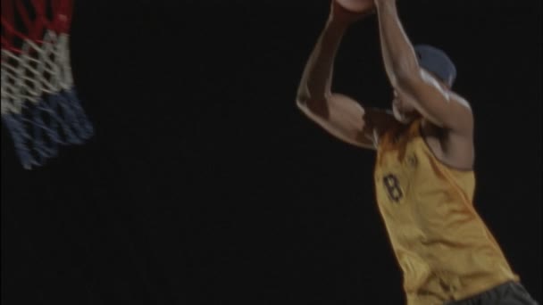 Um homem joga uma bola de basquete no arco — Vídeo de Stock