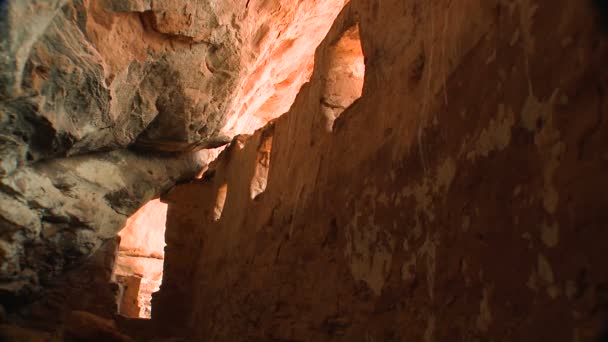 A woman walks through cliff dwelling — Stock Video