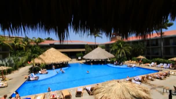 Mensen zwemmen in het zwembad van het resort — Stockvideo