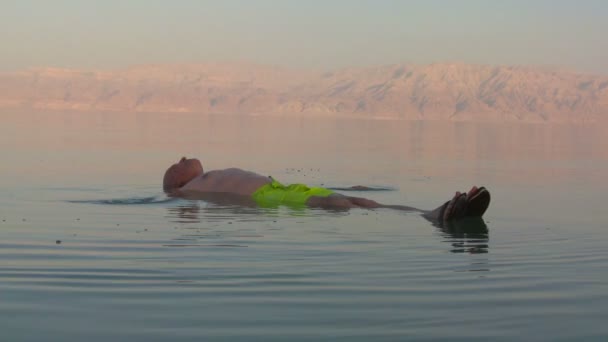 Человек плавает в Мертвом море — стоковое видео