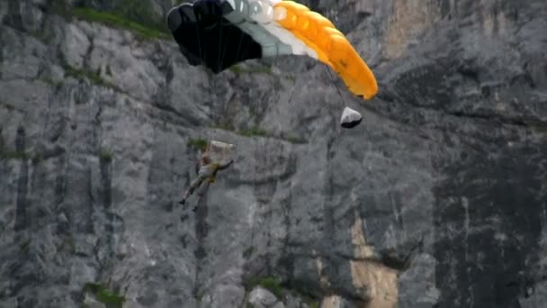 Man paraglides genom ett berg — Stockvideo