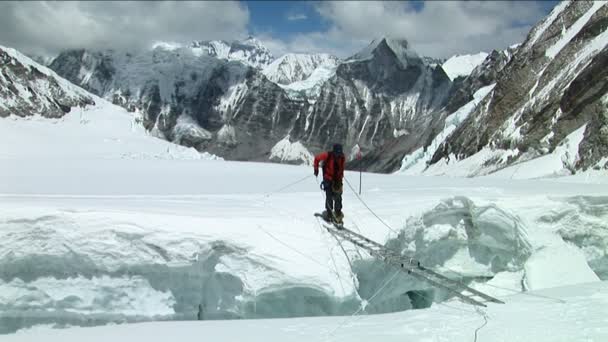 Альпинист пересекает короткую лестницу — стоковое видео