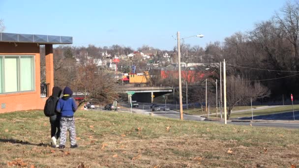 Ragazzi camminano su una collina sopra la città — Video Stock