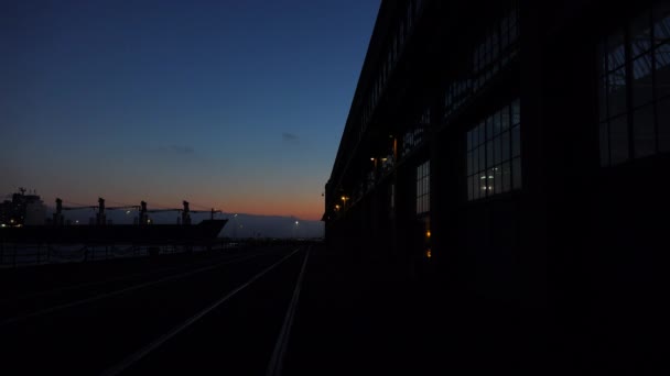 Buque de carga pasa almacén al atardecer — Vídeos de Stock