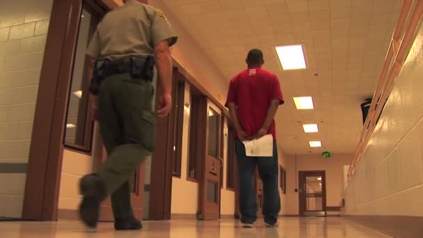 Crime suspect led down a hall — Stock Video