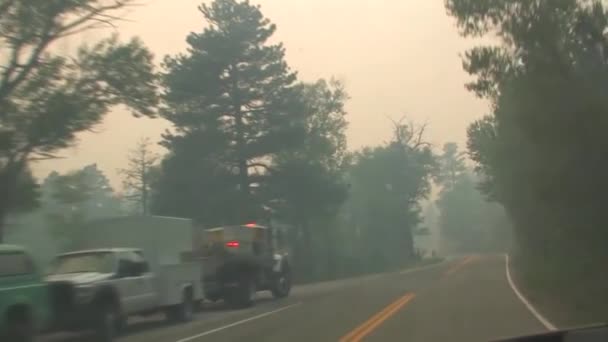 Rijden langs een weg met rook van een bosbrand vertroebelt weergave. — Stockvideo