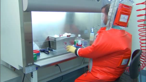 Ilmuwan memakai pakaian biohazard untuk mempelajari virus. — Stok Video