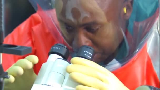 Учёный носит костюм биологической опасности для изучения вирусов — стоковое видео