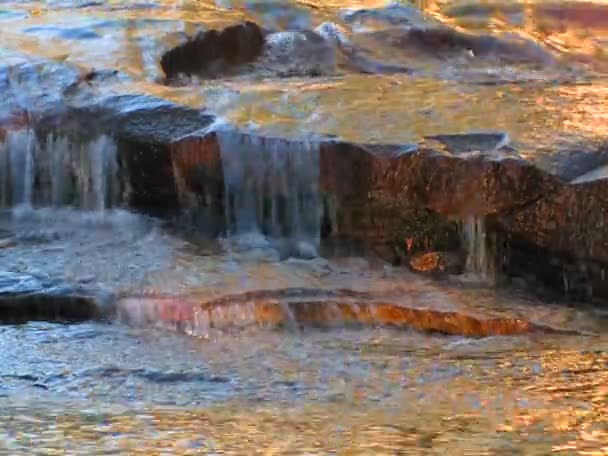 A água flui sobre rochas planas — Vídeo de Stock