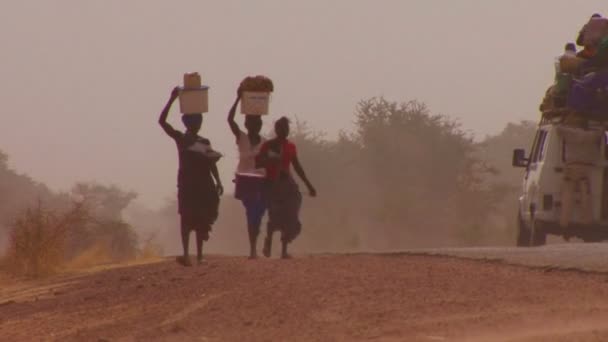 Frauen, die Waren auf dem Kopf tragen — Stockvideo