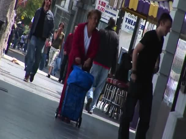 Pedestres caminham em um distrito comercial — Vídeo de Stock