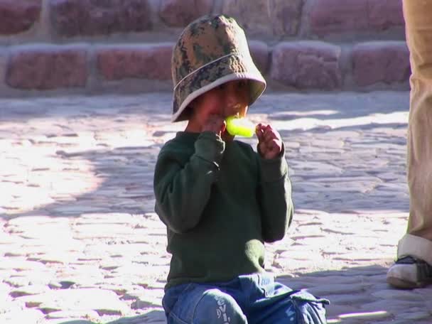 A Latin-amerikai fiú ül a földön — Stock videók