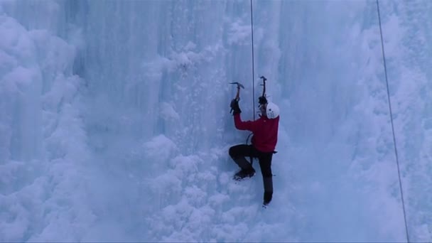 Hombre escalando una cascada congelada — Vídeos de Stock