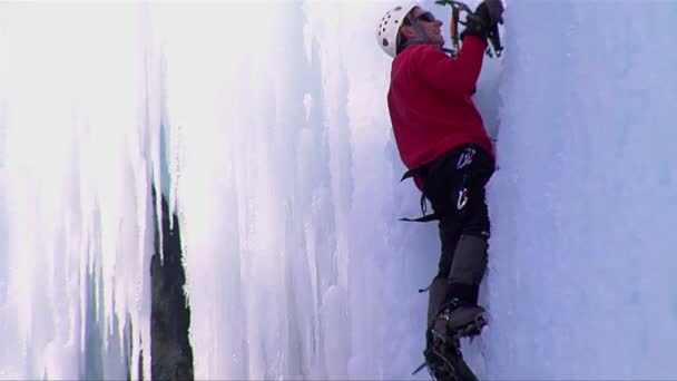 Чоловік піднімається на замерзлий водоспад — стокове відео