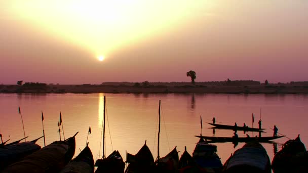 Los pescadores reman al atardecer en el río Níger — Vídeos de Stock