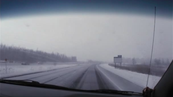 Auto reizen op een besneeuwde weg — Stockvideo