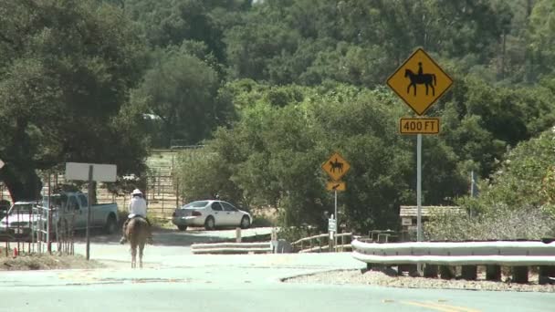 Horse riders to a horse crossing sign — Stock Video