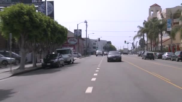 Un coche viaja por una calle — Vídeos de Stock
