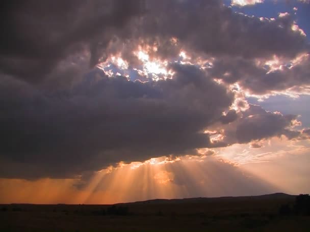 Rayos de sol brotan de nubes oscuras — Vídeo de stock