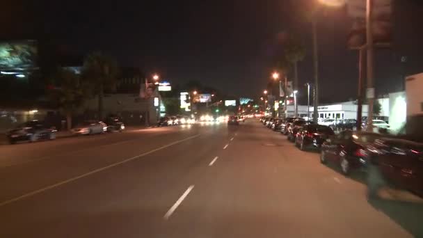 Een auto reist langs een straat — Stockvideo