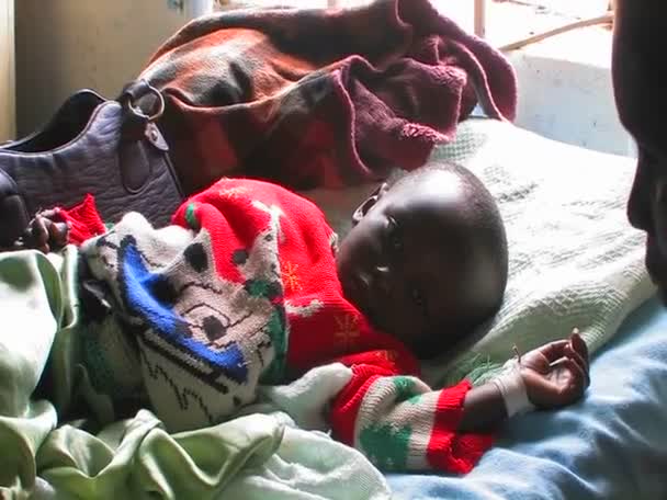 Ребенок лежит в постели в больнице — стоковое видео