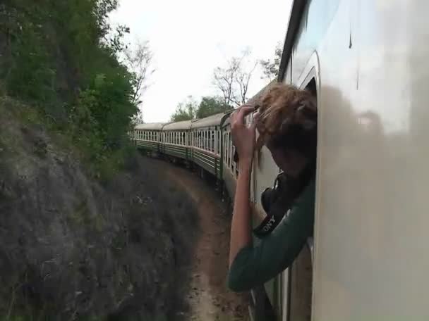 Una mujer saca la cabeza por la ventana — Vídeo de stock