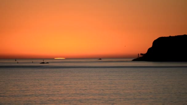 Zonsondergang weerspiegelt off van de golven — Stockvideo