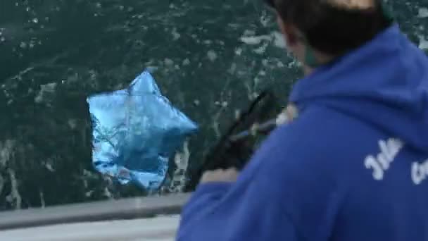 Homem recuperando um balão de papel alumínio do Oceano — Vídeo de Stock