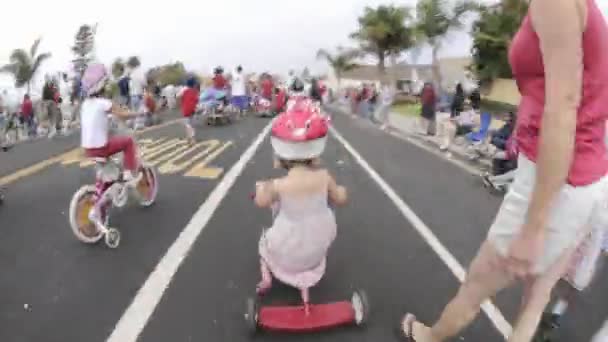 Chica en un triciclo en desfile — Vídeo de stock