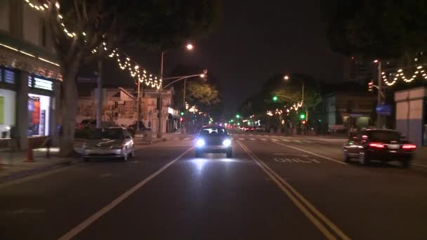 Een auto reist langs een straat — Stockvideo