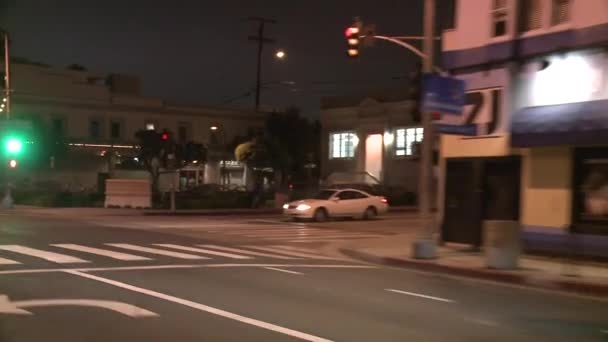 Um carro viaja por uma rua — Vídeo de Stock
