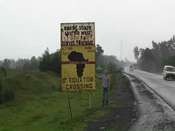 Um homem está ao lado de um sinal — Vídeo de Stock