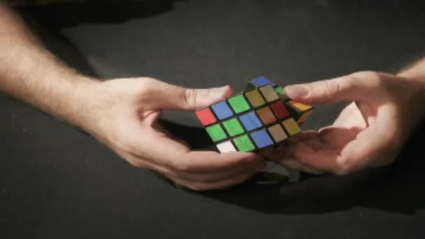 Homem girando cubo de Rubik nas mãos — Vídeo de Stock