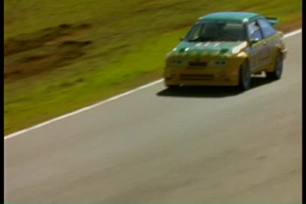 Um carro de corrida dirige em torno de uma pista — Vídeo de Stock