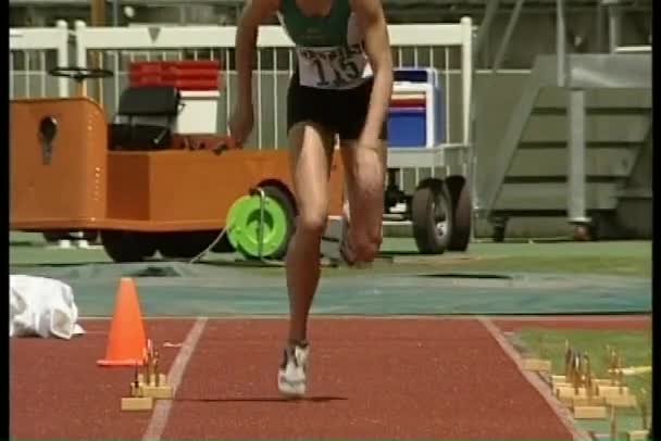 Atleta realiza um salto em comprimento — Vídeo de Stock